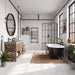 The room has light white concrete-look tiled walls and floors, a woven jute rug, and large multi-pane windows. A modern industrial-style bathroom featuring a black clawfoot bathtub, a rustic wooden double-sink vanity with a gray countertop, a round black-framed mirror, and a black metal-framed glass shower enclosure. 