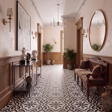 An elegant interior hallway with a black and white patterned tile floor, warm wood wainscoting, wall sconces, a large round mirror, and a carved wooden bench with cushions.